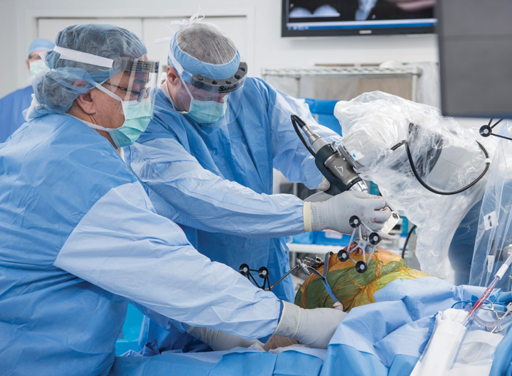 Orthopaedic surgeon using robotic arm system during knee replacement surgery in India